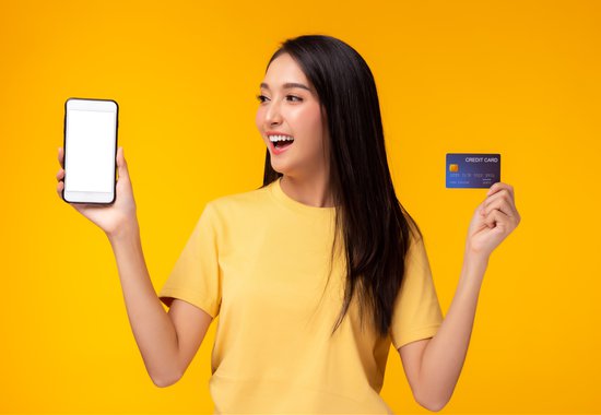Gen Z woman with smartphone and credit card
